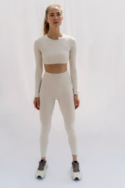 Woman wearing a beige athletic outfit on a white background