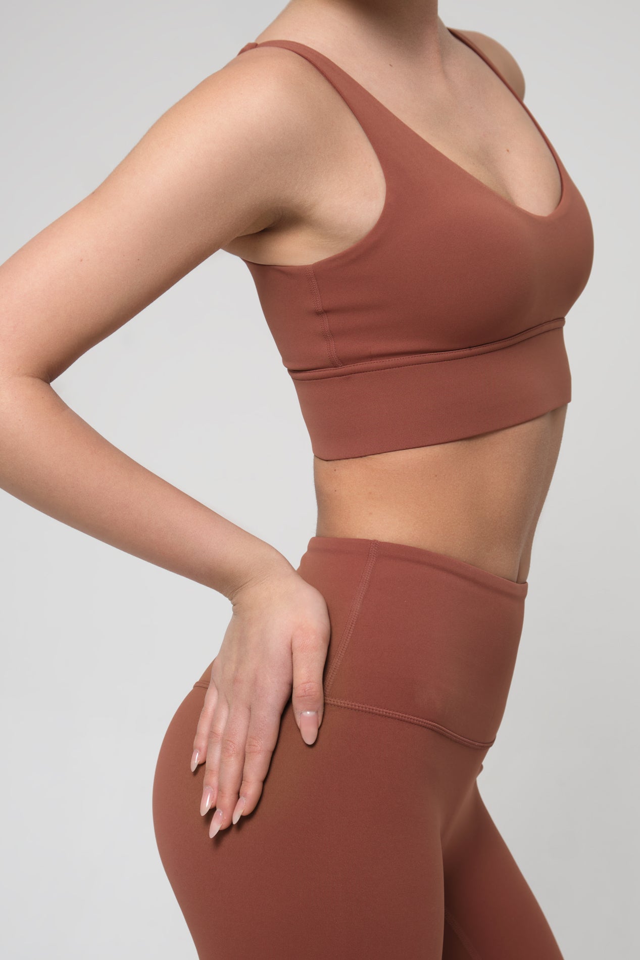Brown sports bra and leggings set on a plain background