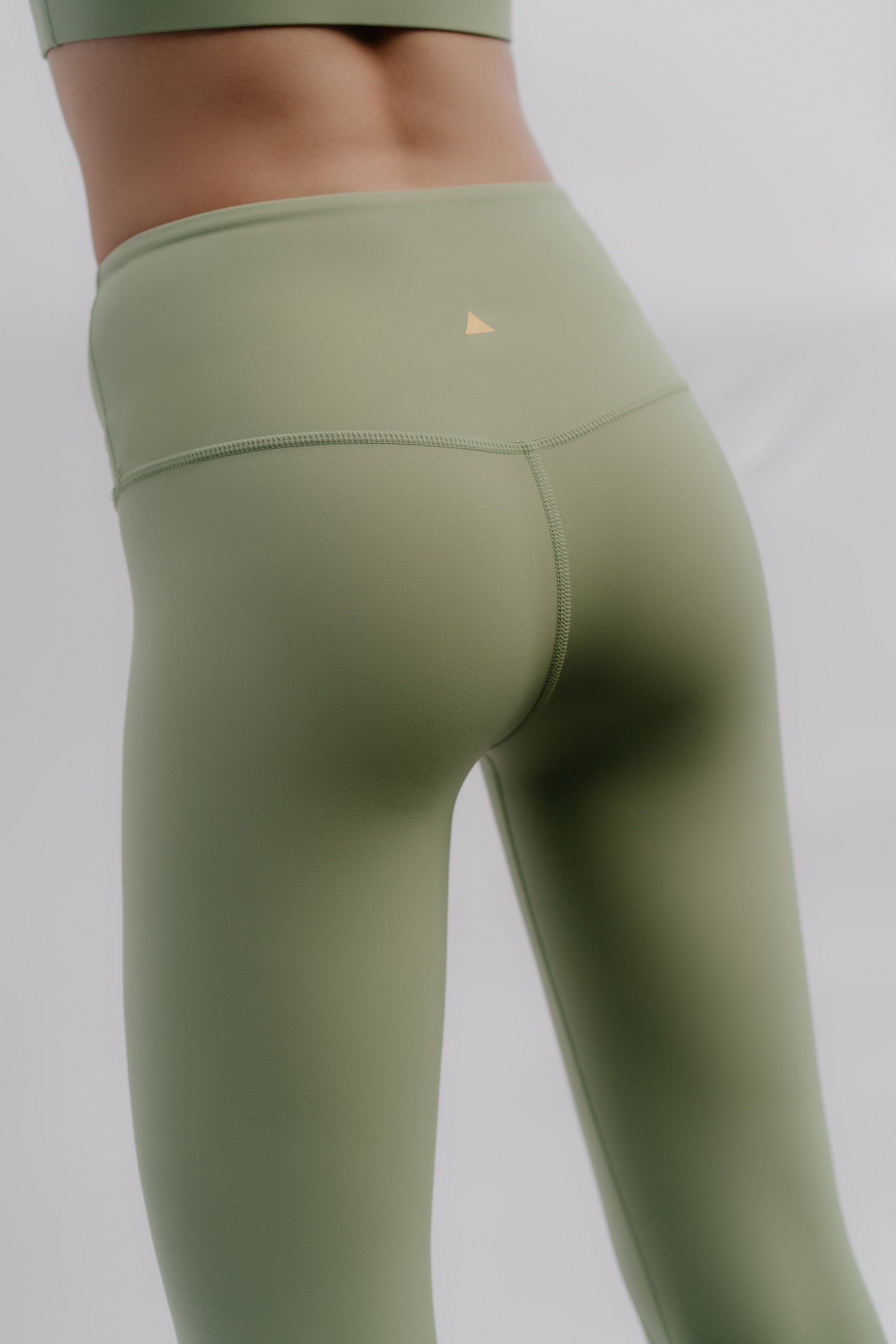 Green leggings with a small logo on a plain background