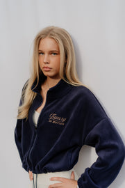 Woman wearing a navy blue jacket with text on a plain background