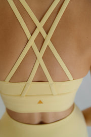 Yellow strappy top on a plain background