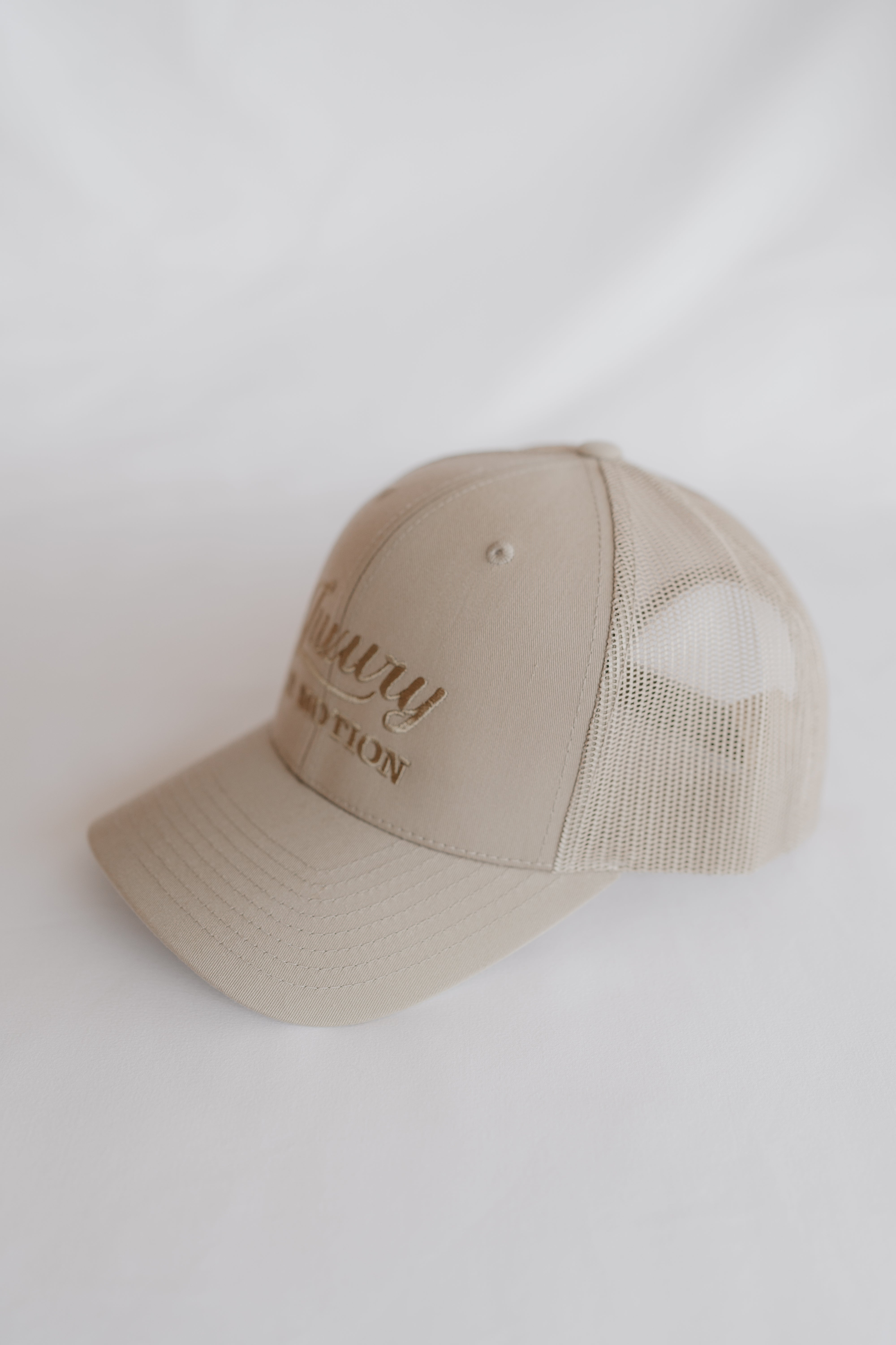 Beige baseball cap with text on a white background
