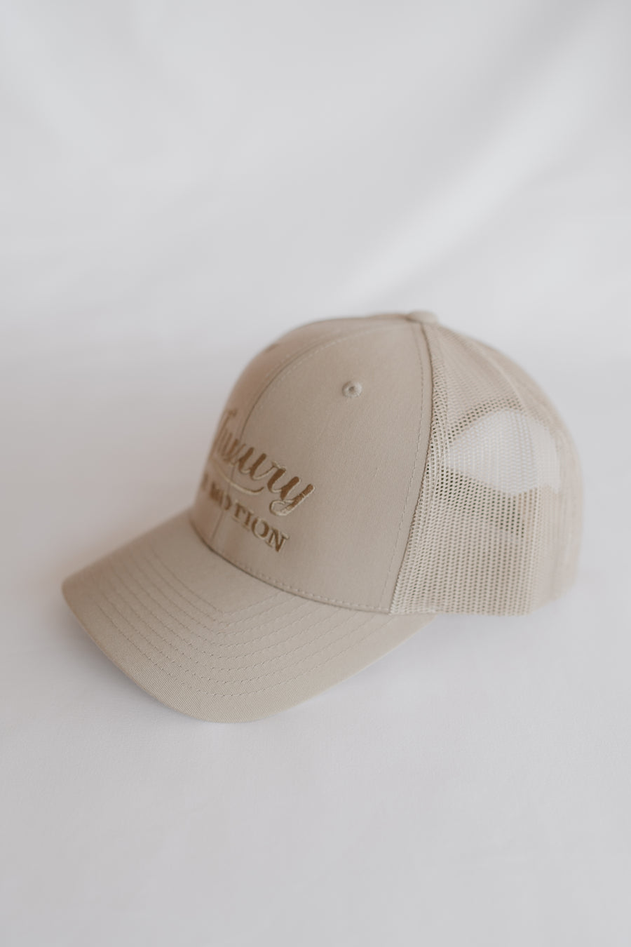 Beige baseball cap with text on a white background