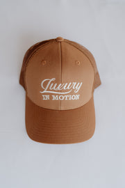Brown cap with 'Luxury in Motion' text on a white background
