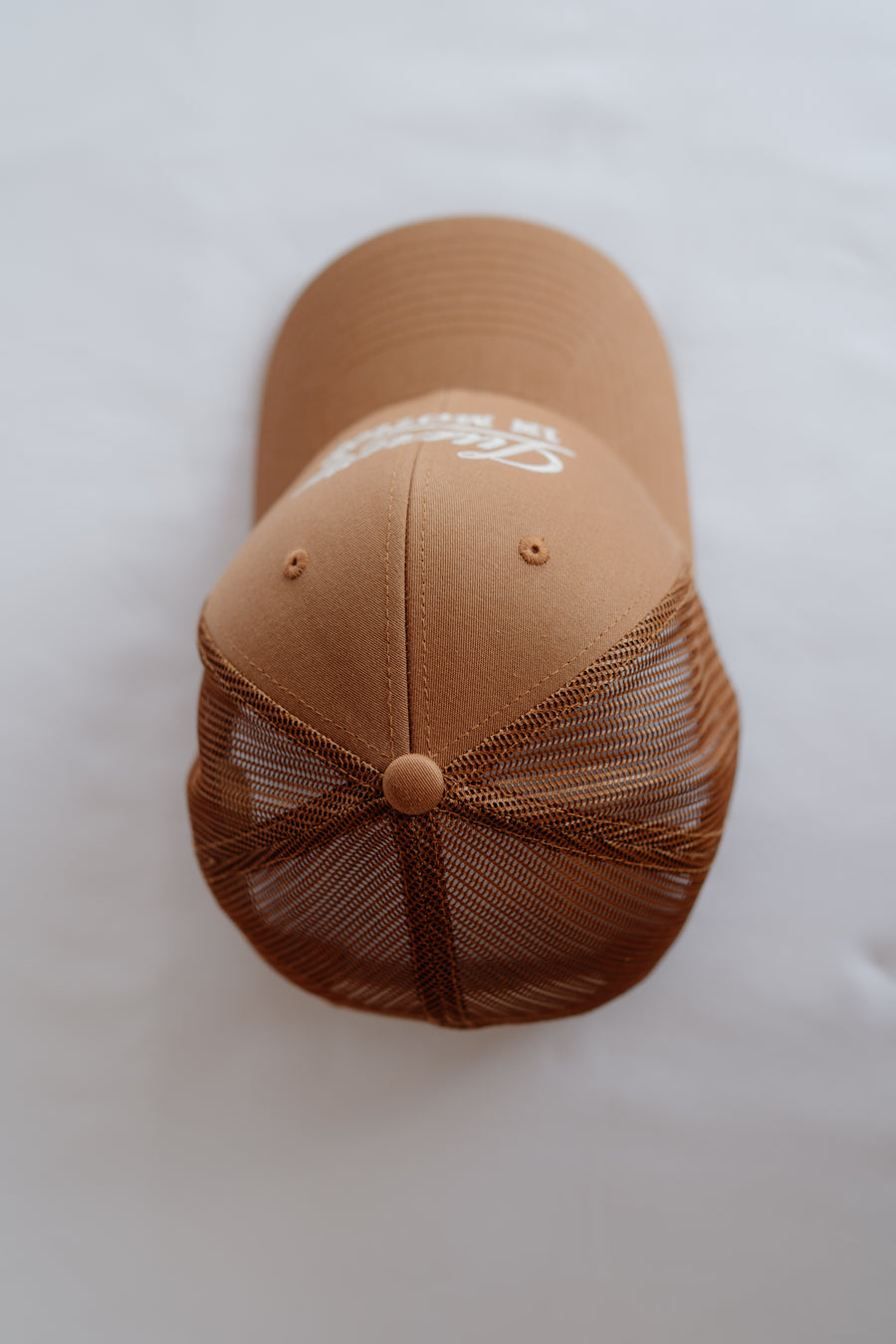 Brown baseball cap with mesh back on a white background