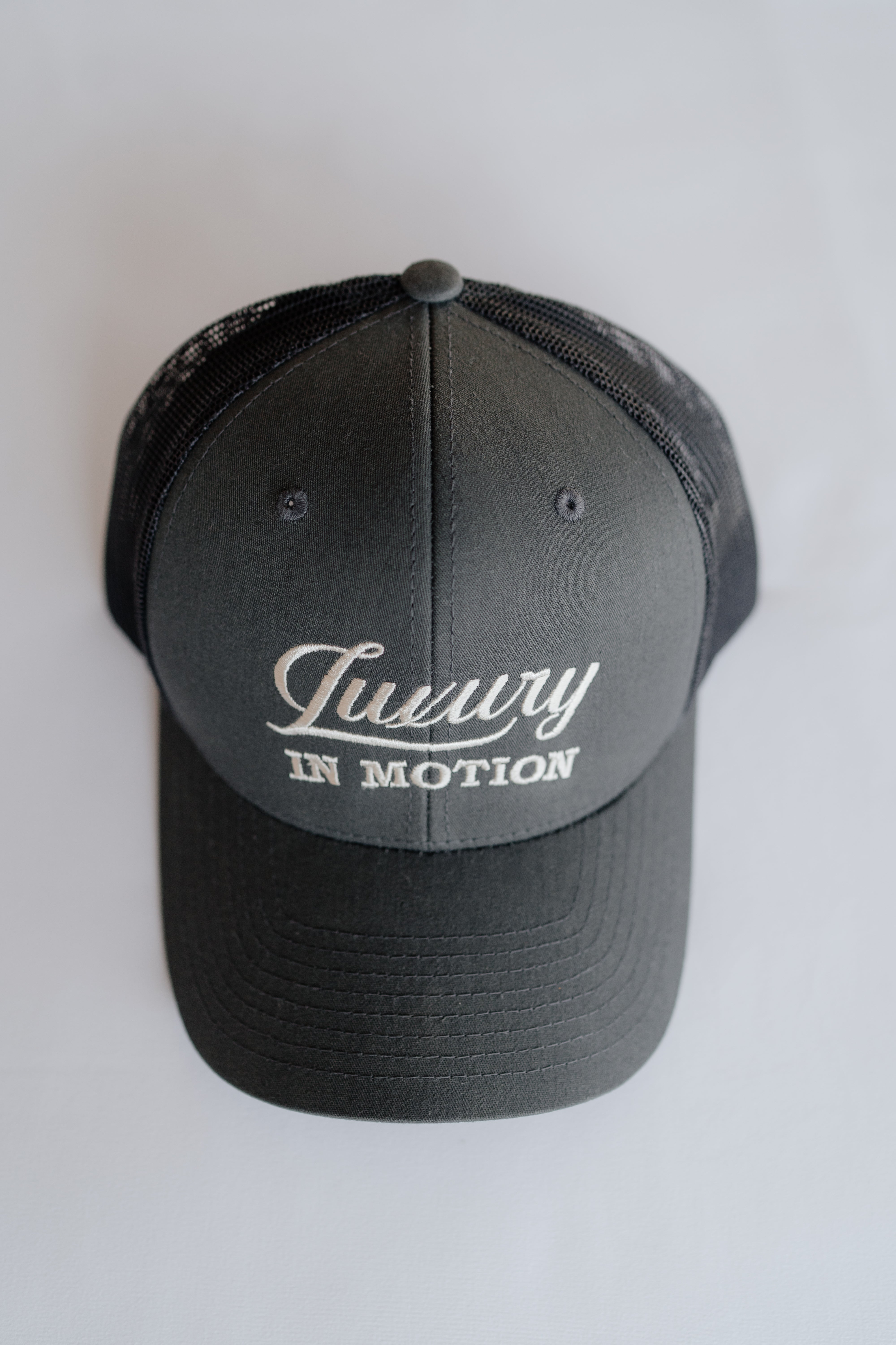 Grey cap with 'Luxury in Motion' text on a white background