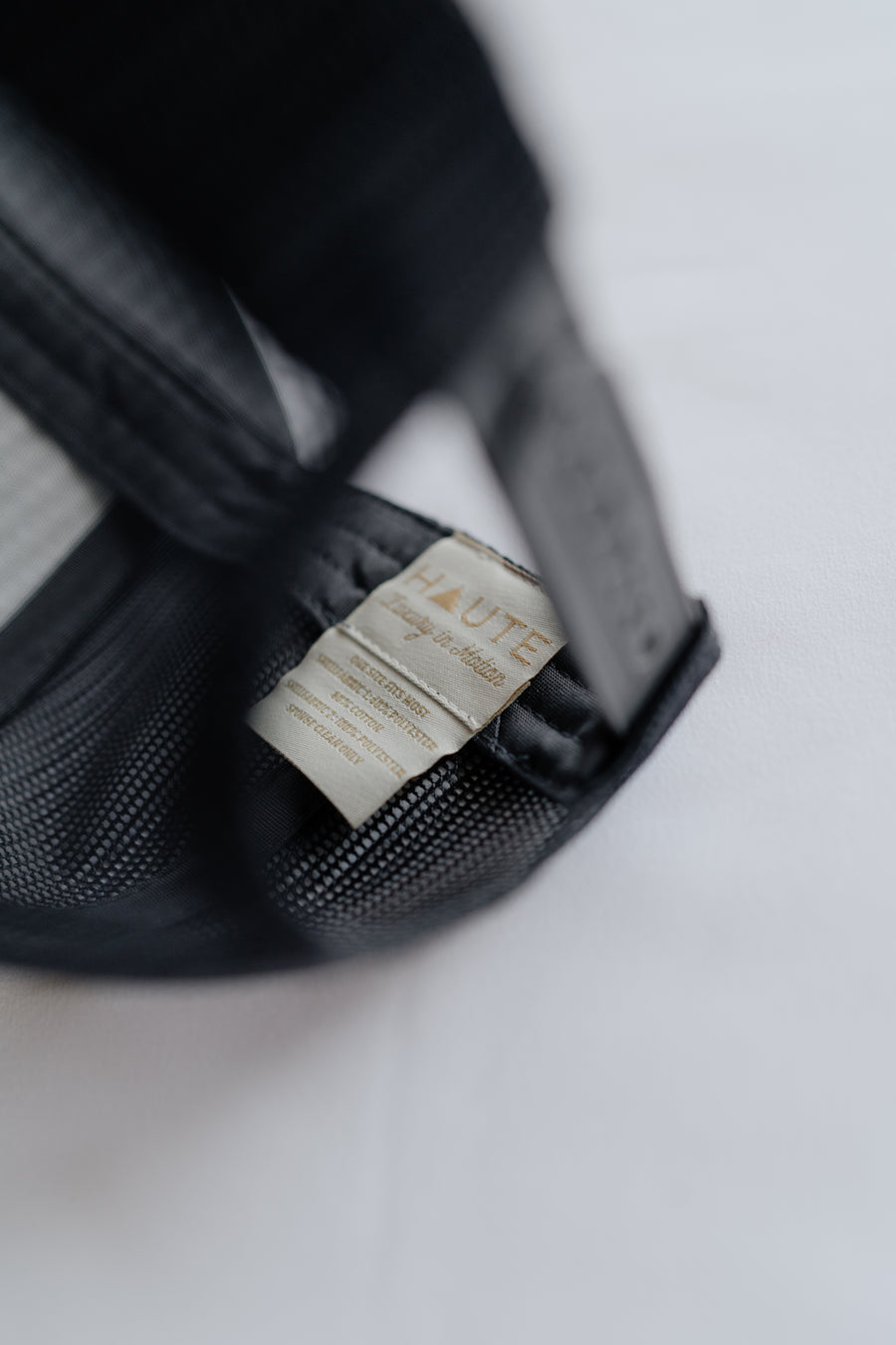 Grey cap with a visible brand tag on a light  background