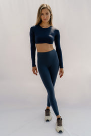 Woman wearing a dark blue athletic outfit on a white background