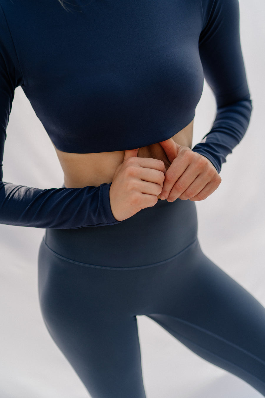 Woman wearing a blue athletic outfit on a light background