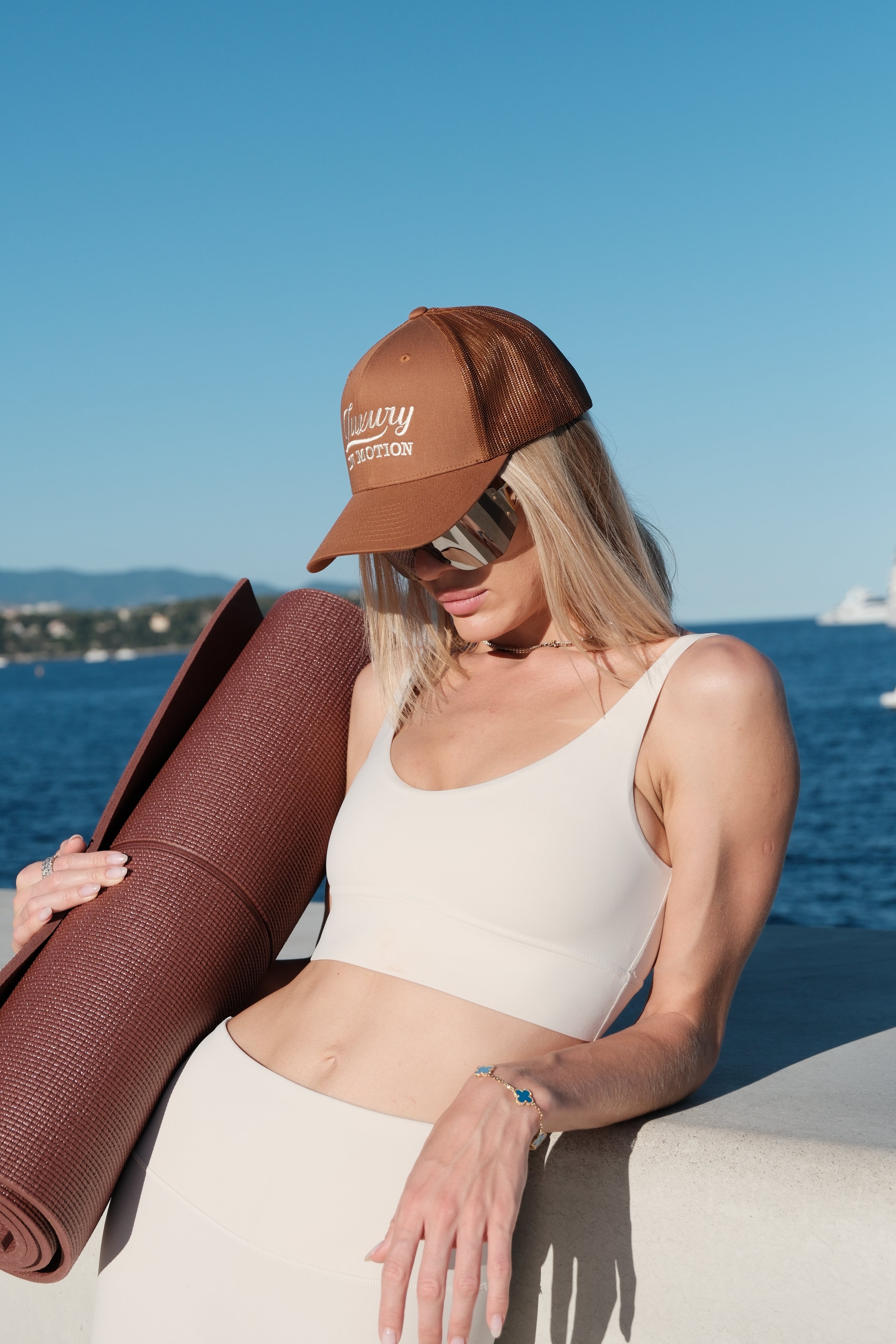 Woman holding a yoga mat against a blue wall