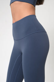 Blue leggings worn by a woman on a white background