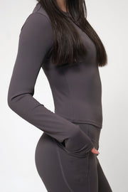 Woman wearing a gray long-sleeve top and pants on a white background