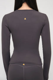 Gray long-sleeve athletic top with a small triangle logo on a plain background