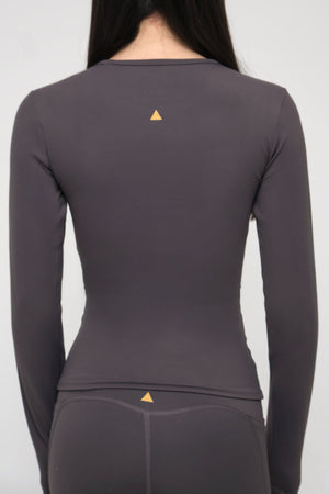 Gray long-sleeve athletic top with a small triangle logo on a plain background