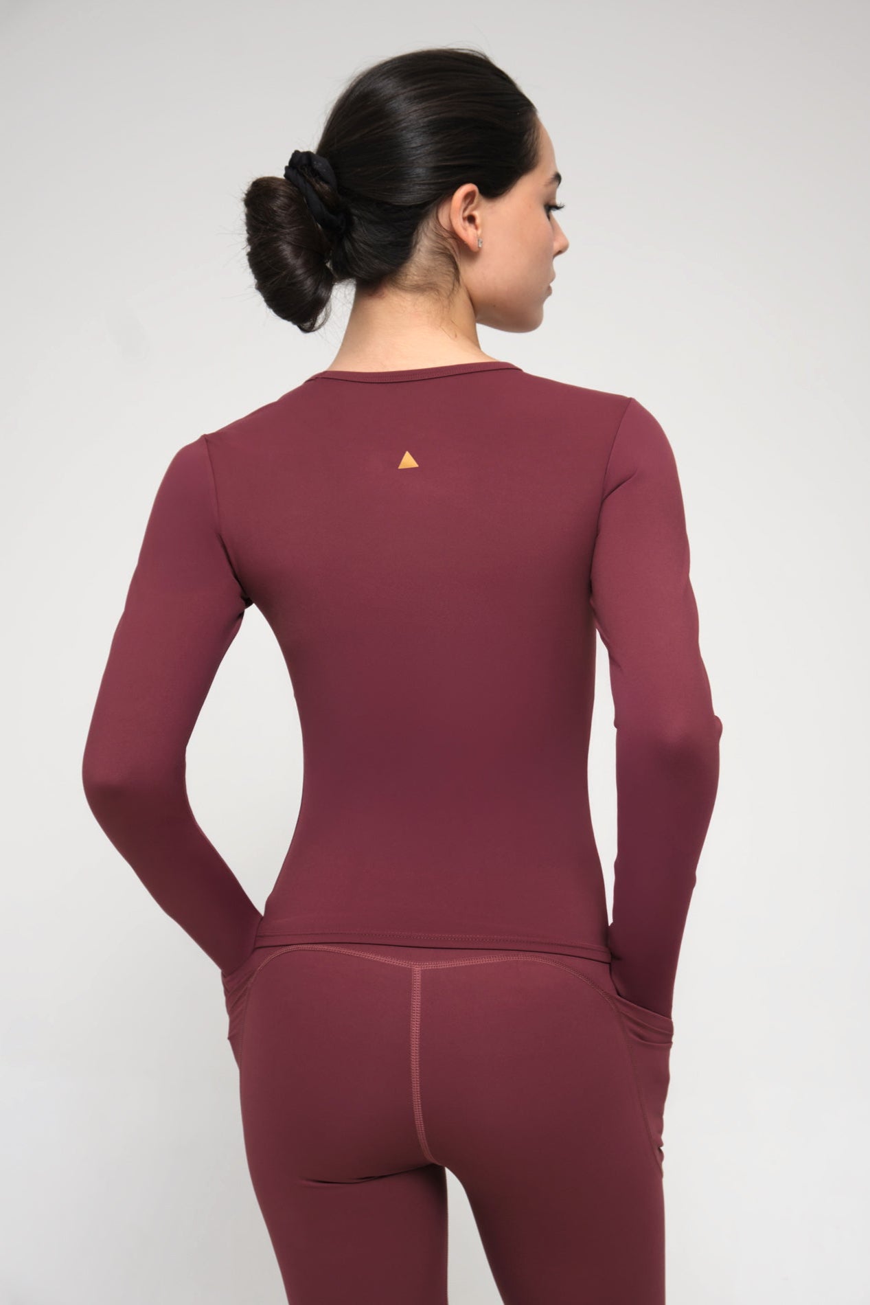 Burgundy athletic outfit with a small logo on the back against a white background