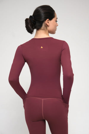 Burgundy athletic outfit with a small logo on the back against a white background