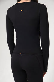 Black long-sleeve top with a small yellow triangle logo on a gray background