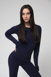 Woman wearing a navy blue outfit against a gray background