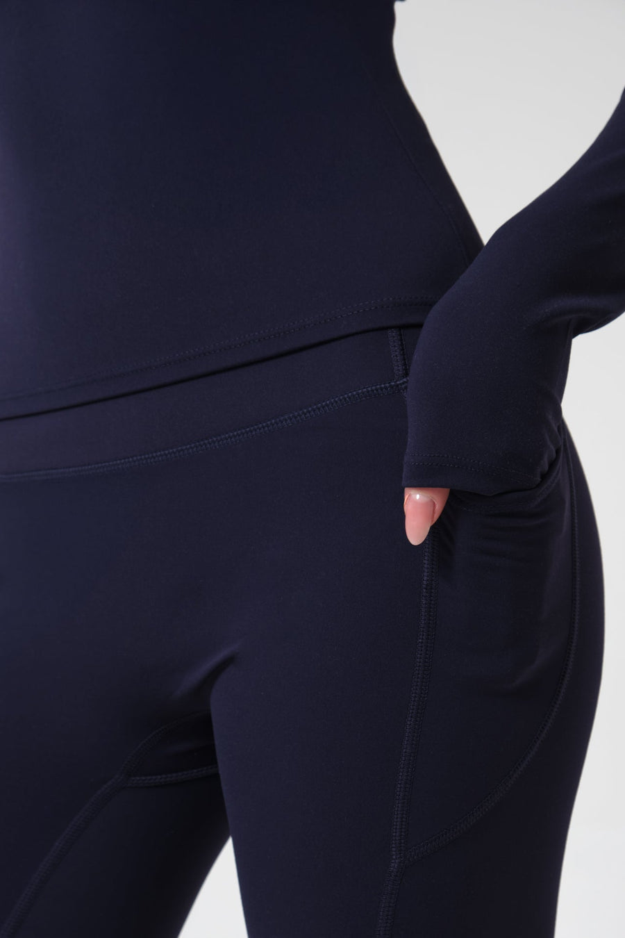 Navy blue athletic outfit with a focus on the pants on a white background