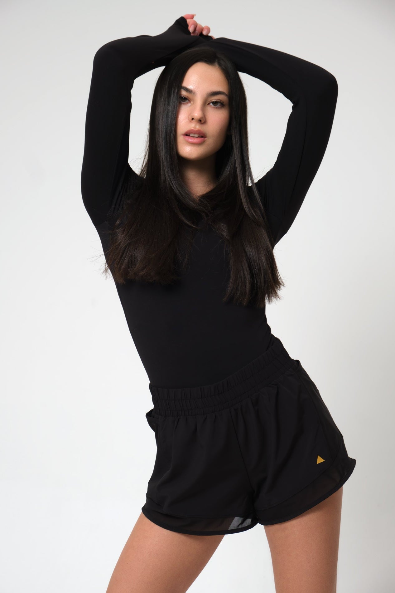 Woman wearing a black outfit with a plain background