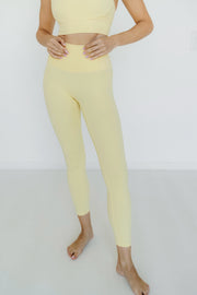 Woman wearing a yellow athletic outfit on a white background