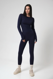 Woman wearing a navy blue athletic outfit on a white background