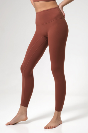 Brown leggings worn by a woman on a white background
