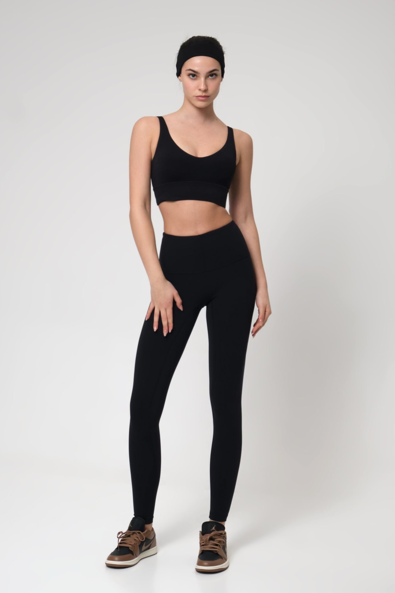 Woman wearing a black athletic outfit on a white background