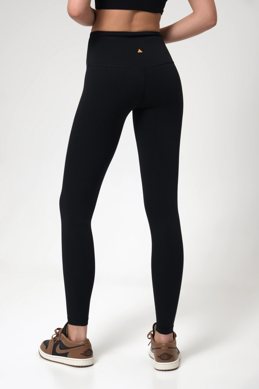 Woman wearing black leggings on a white background