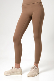 Brown leggings worn by a woman on a white background