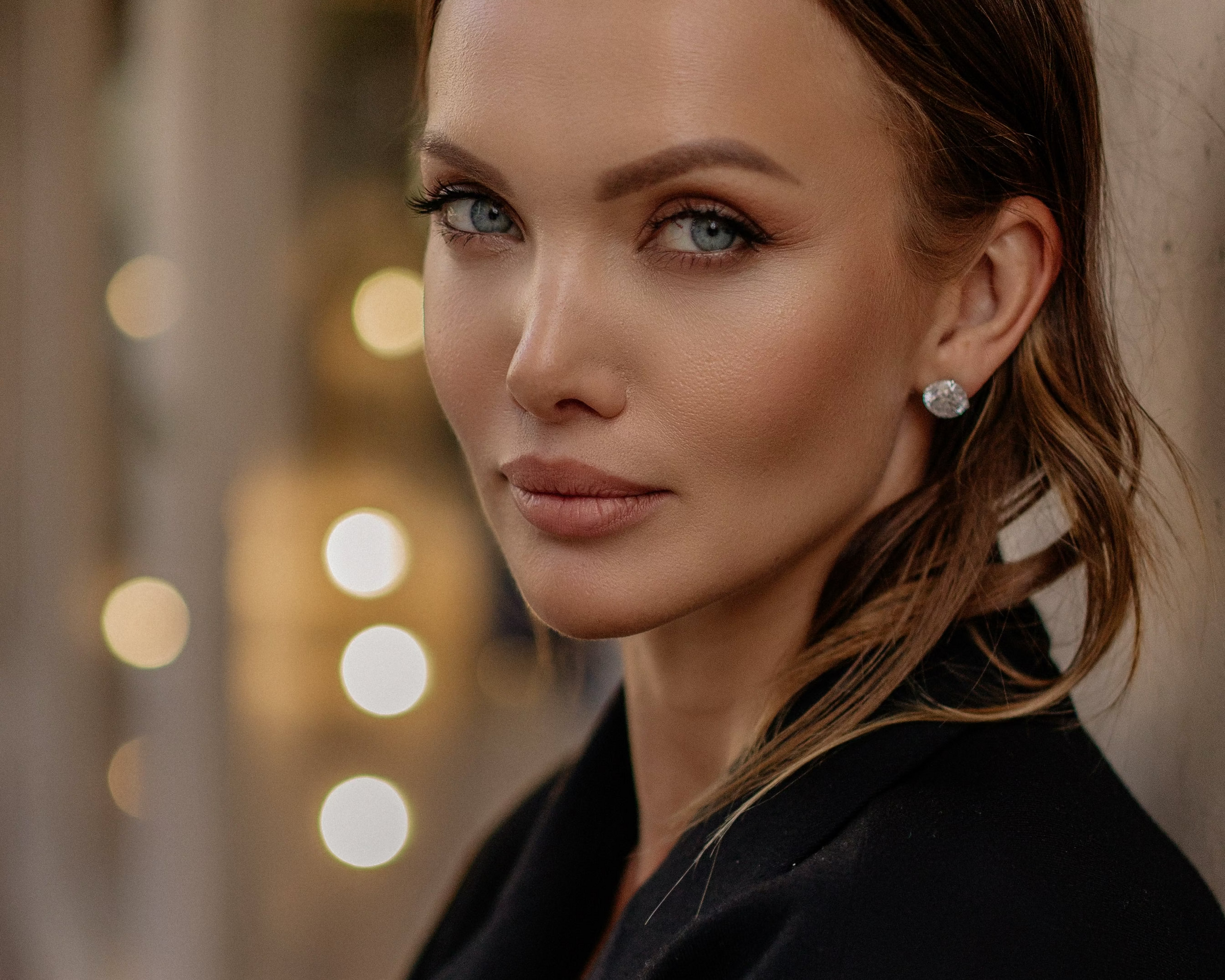 Natalia Ardatovskaya wearing a black jacket with blurred lights in the background