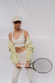 Woman holding a tennis racket against a plain background