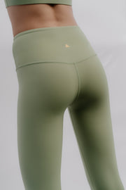 Green leggings with a small logo on a plain background