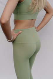 Person wearing a green athletic outfit on a plain background